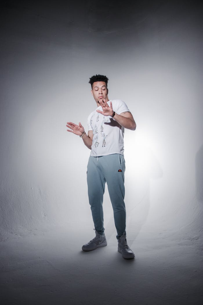 Stylish male model posing confidently in trendy activewear during a studio photoshoot.